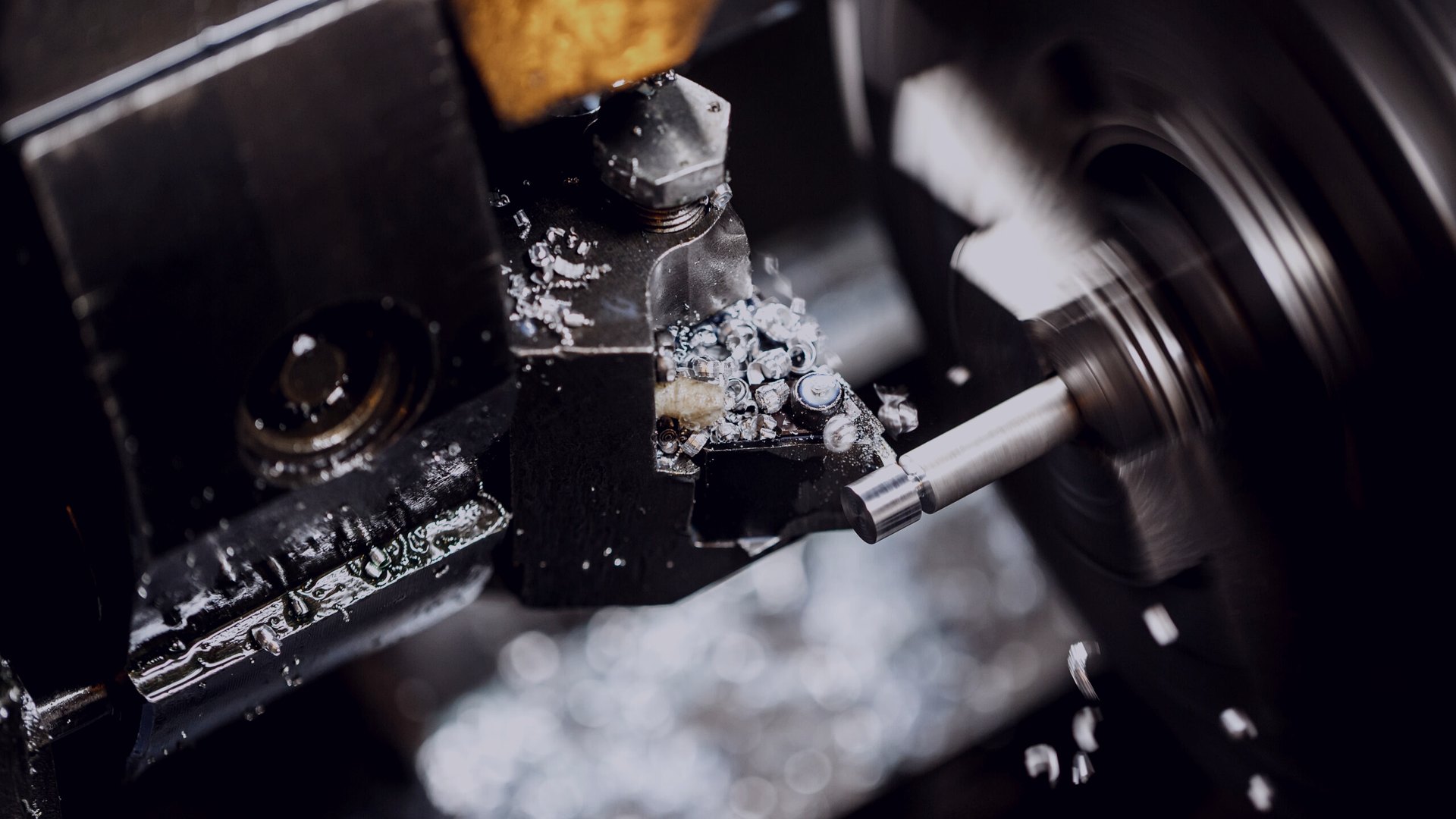 Torno CNC mecanizando una flecha de acero inoxidable con refrigerante